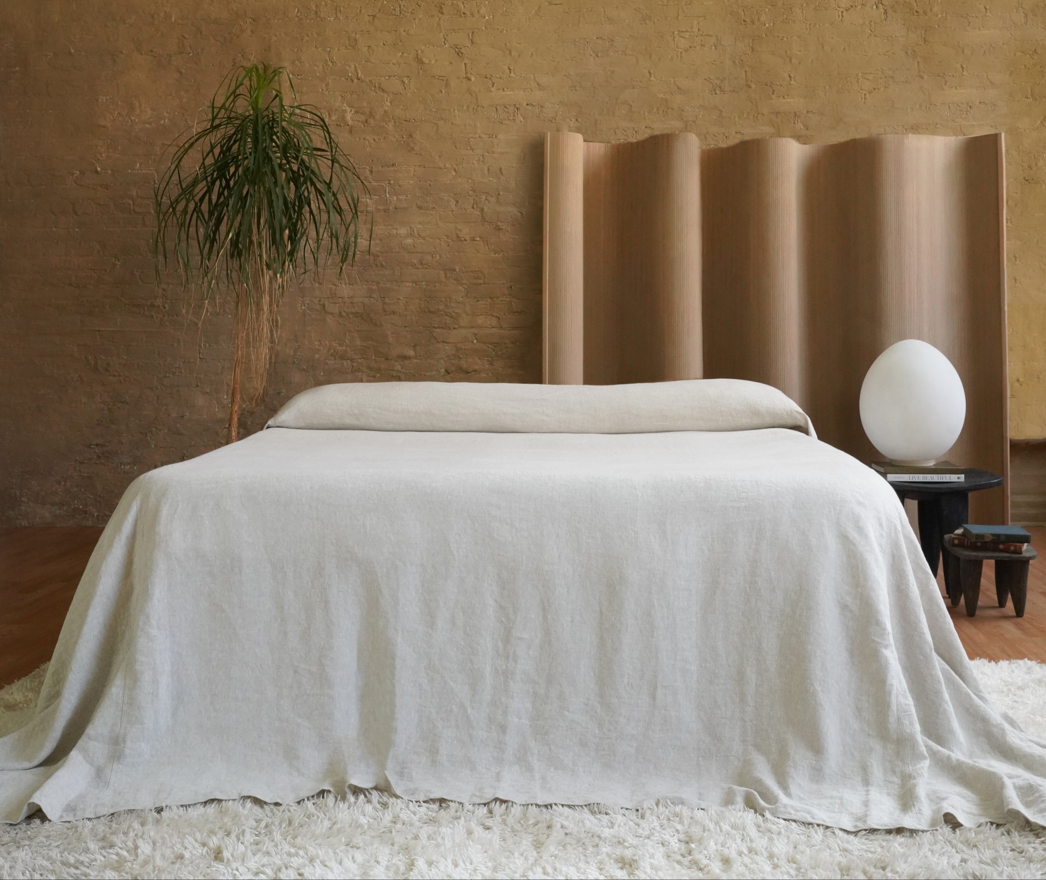 Oversized 350 GSM heavyweight linen bedspread in Natural color on a King bed showing floor-length luxury puddle drape