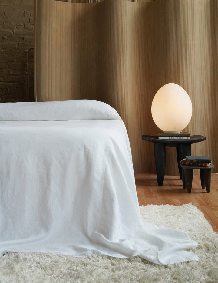 Oversized crisp white 350 GSM heavyweight linen bedspread on a King bed with floor-length luxury puddle drape