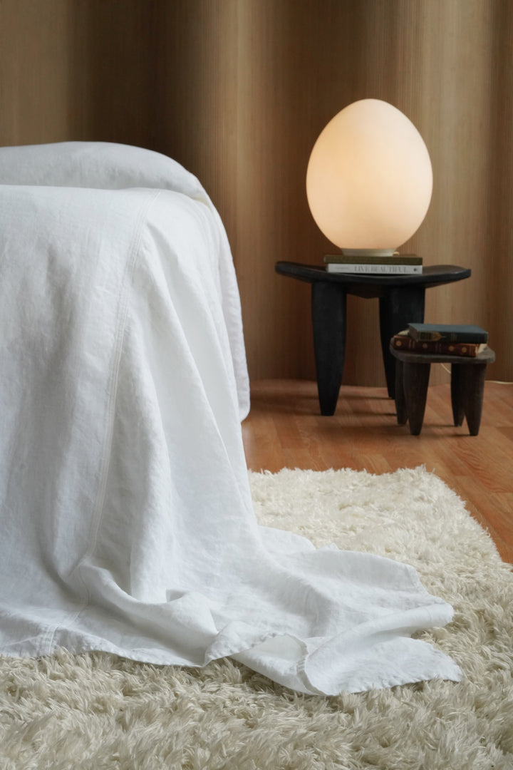 Bright white luxury linen bedspread (124x128) providing full floor-to-floor coverage on a high-profile mattress